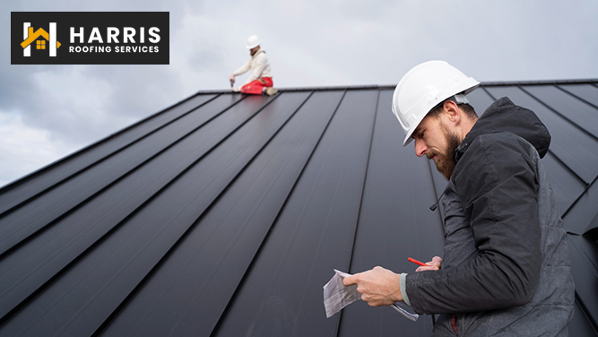 Two workers inspecting and maintaining a standing seam metal roof